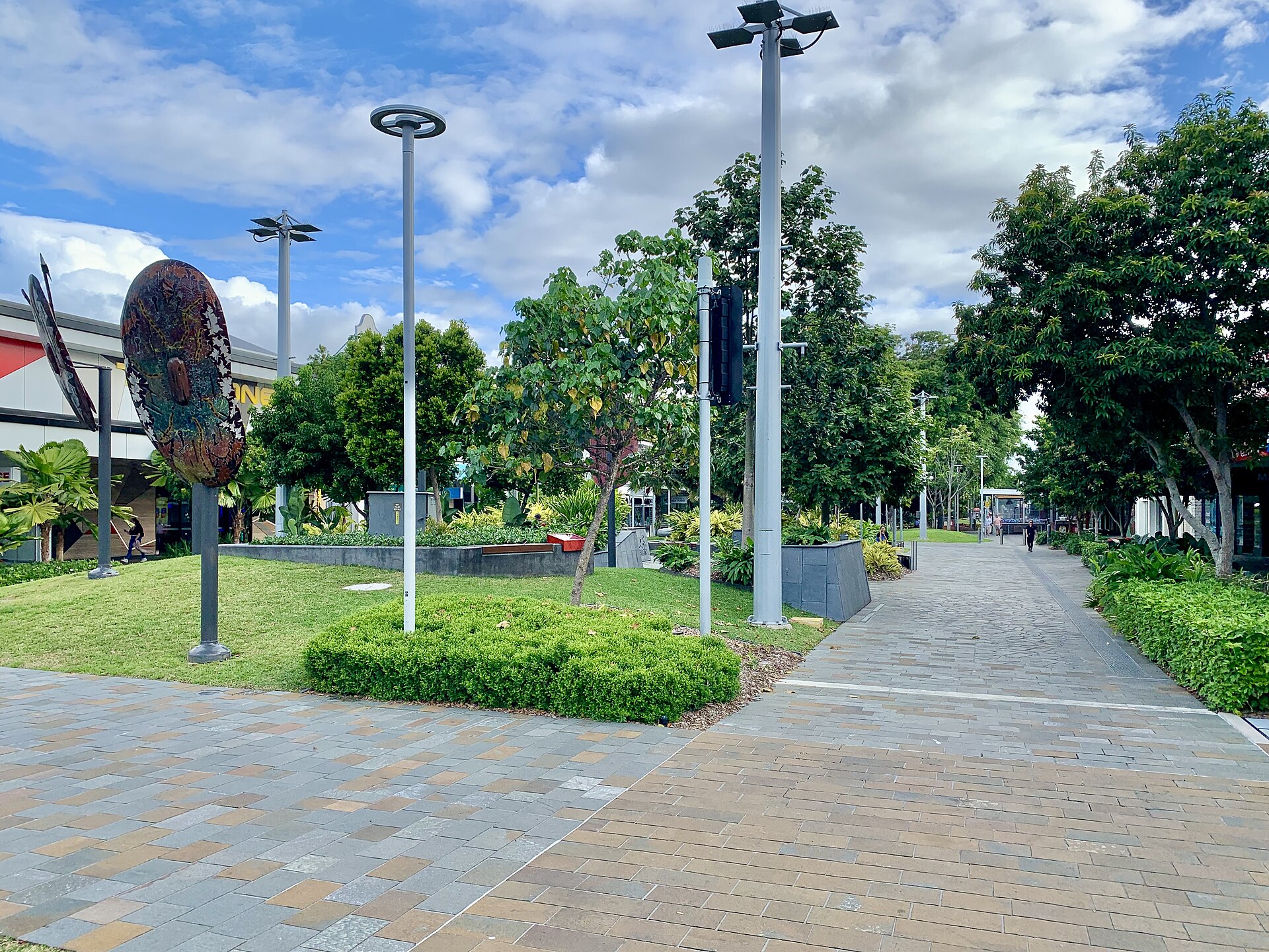 Shields Street in the Cairns CBD with paving, trees and an artwork on the left