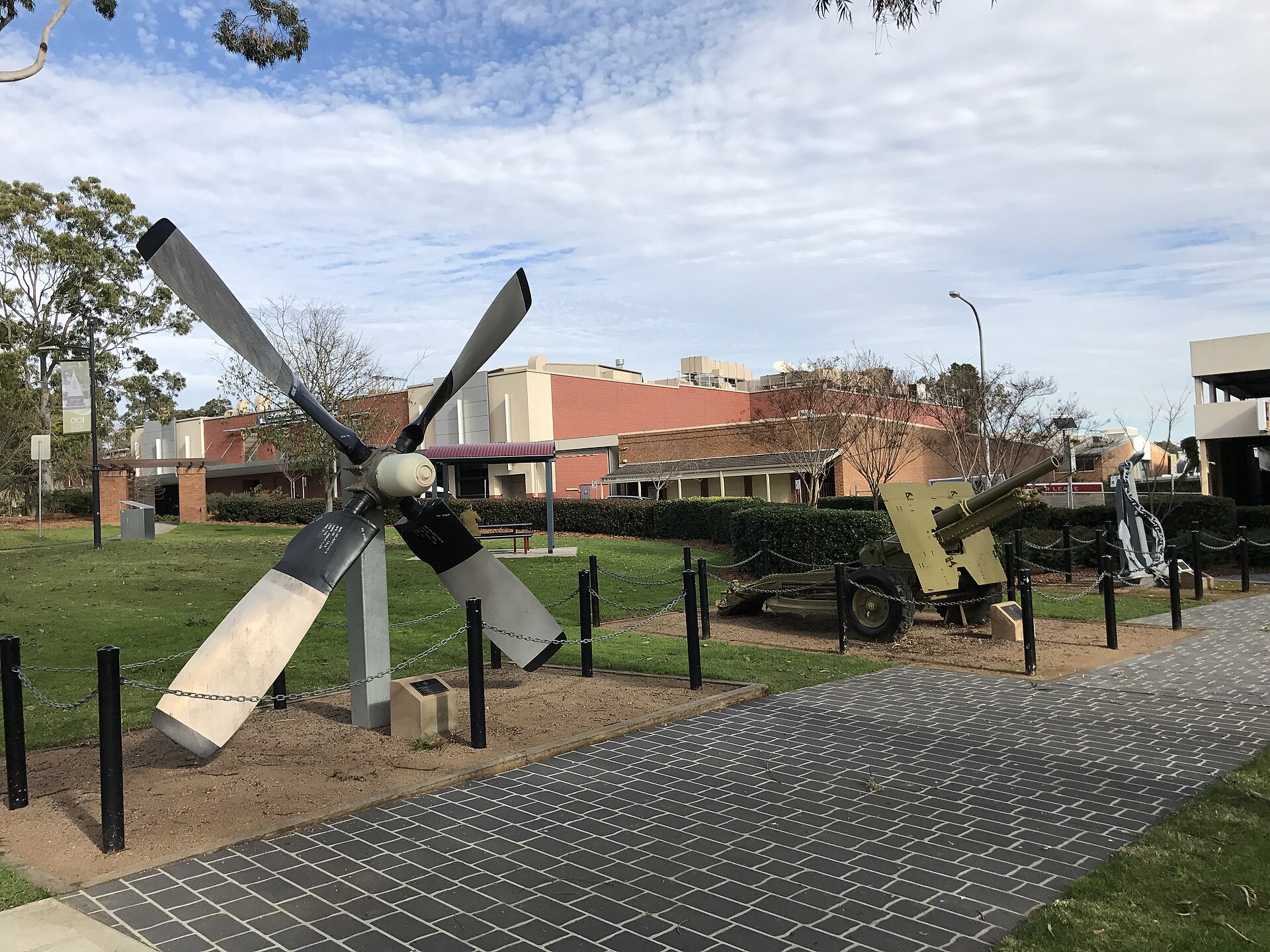 Memorials at Mawson Park, Campbelltown, with a propeller and a field gun on the lawn