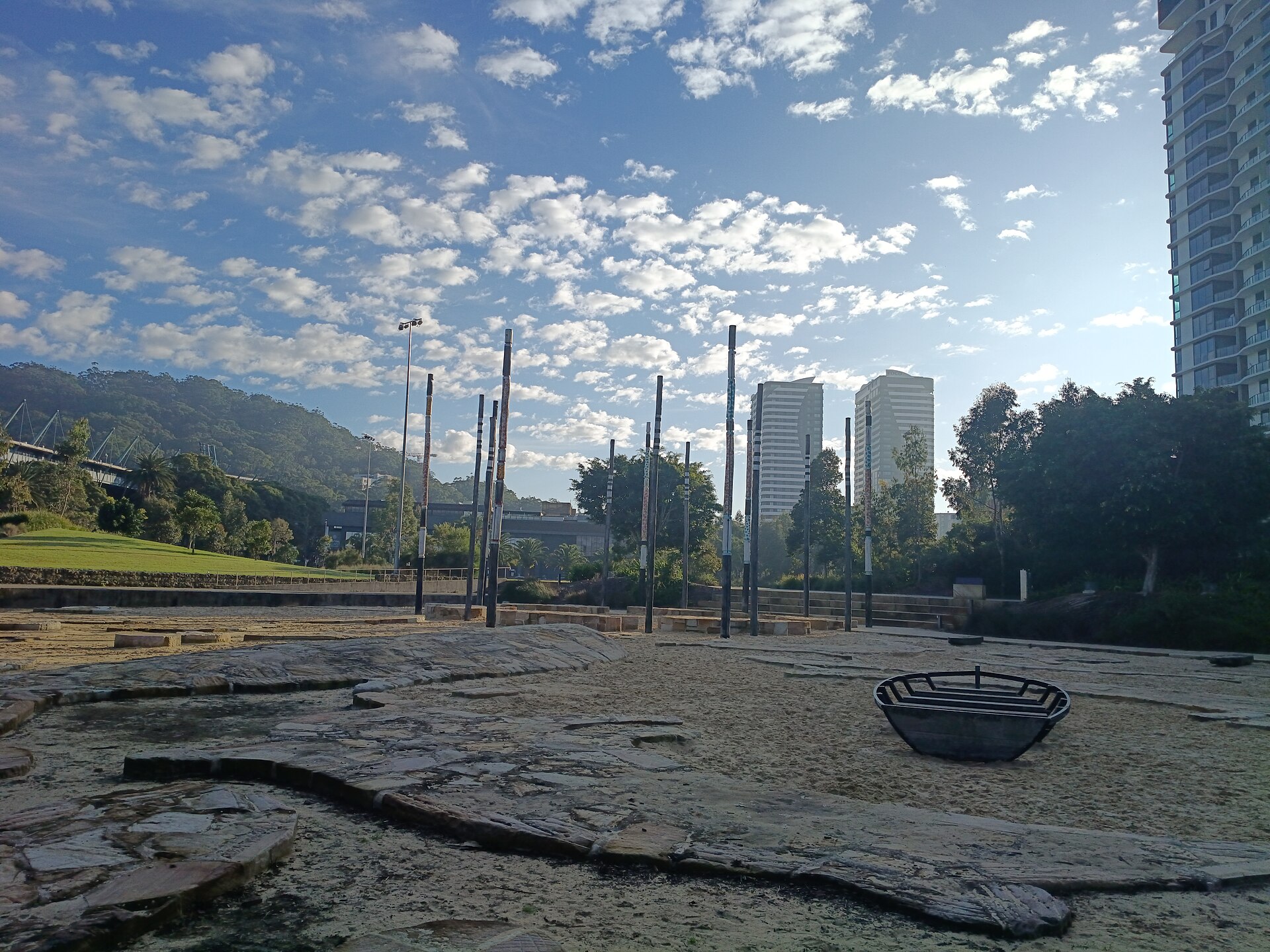 Gosford Leagues Club Park in Gosford, with tall poles, trees and apartment towers behind