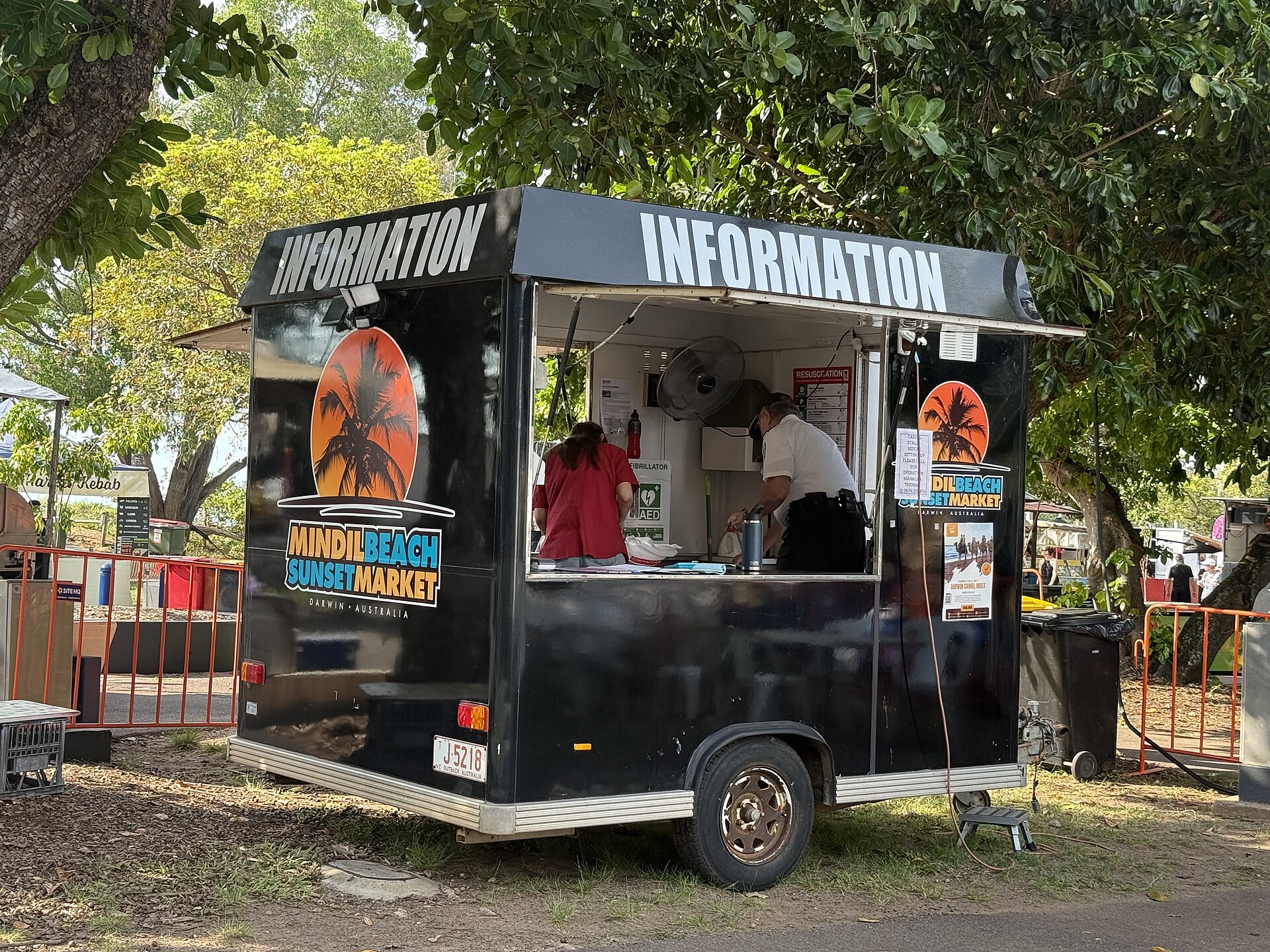 The information booth at Mindil Beach Sunset Market, a black trailer with an Information sign, photographed in October 2025