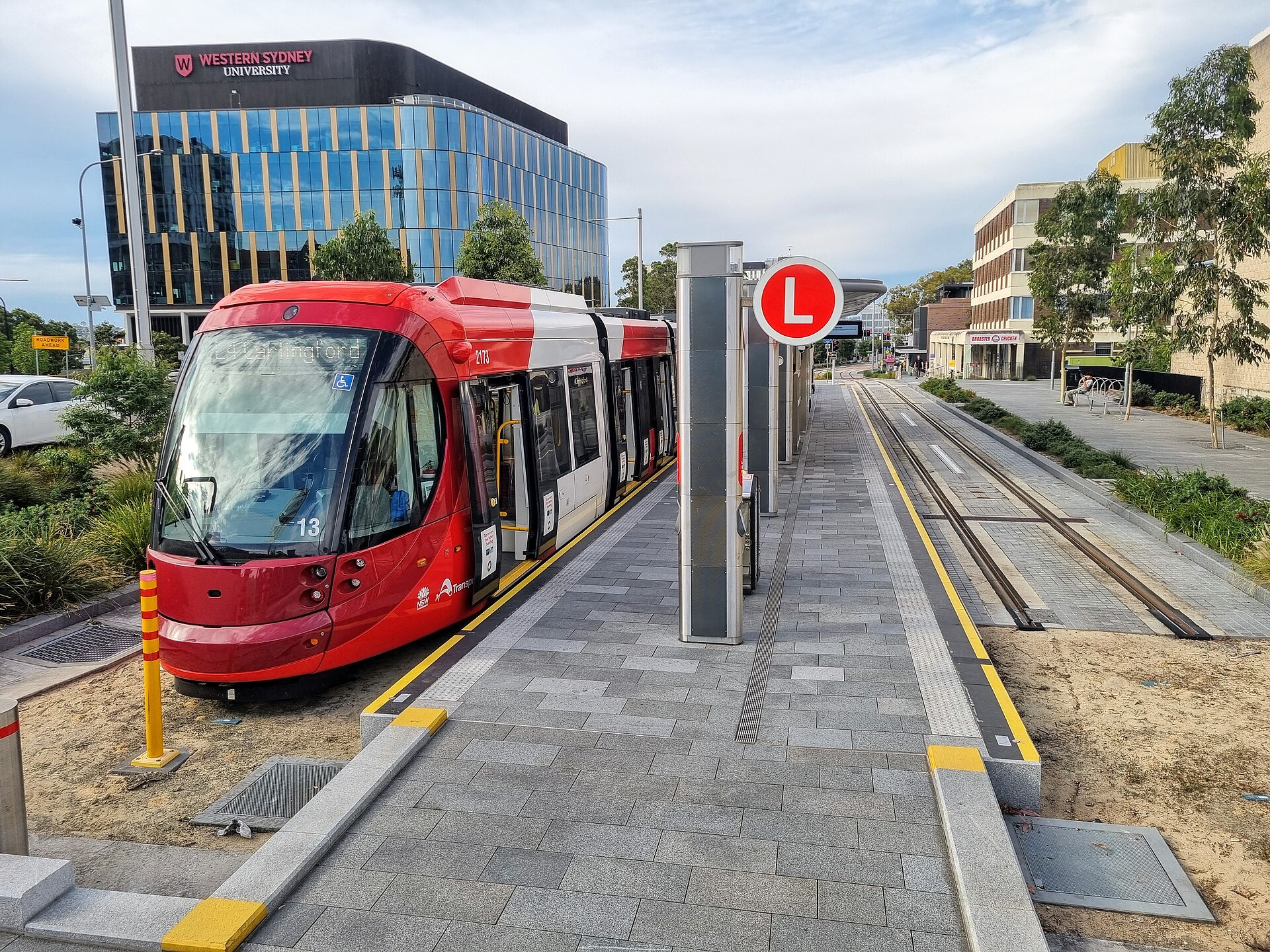 A red and white Parramatta Light Rail tram showing Carlingford as its destination