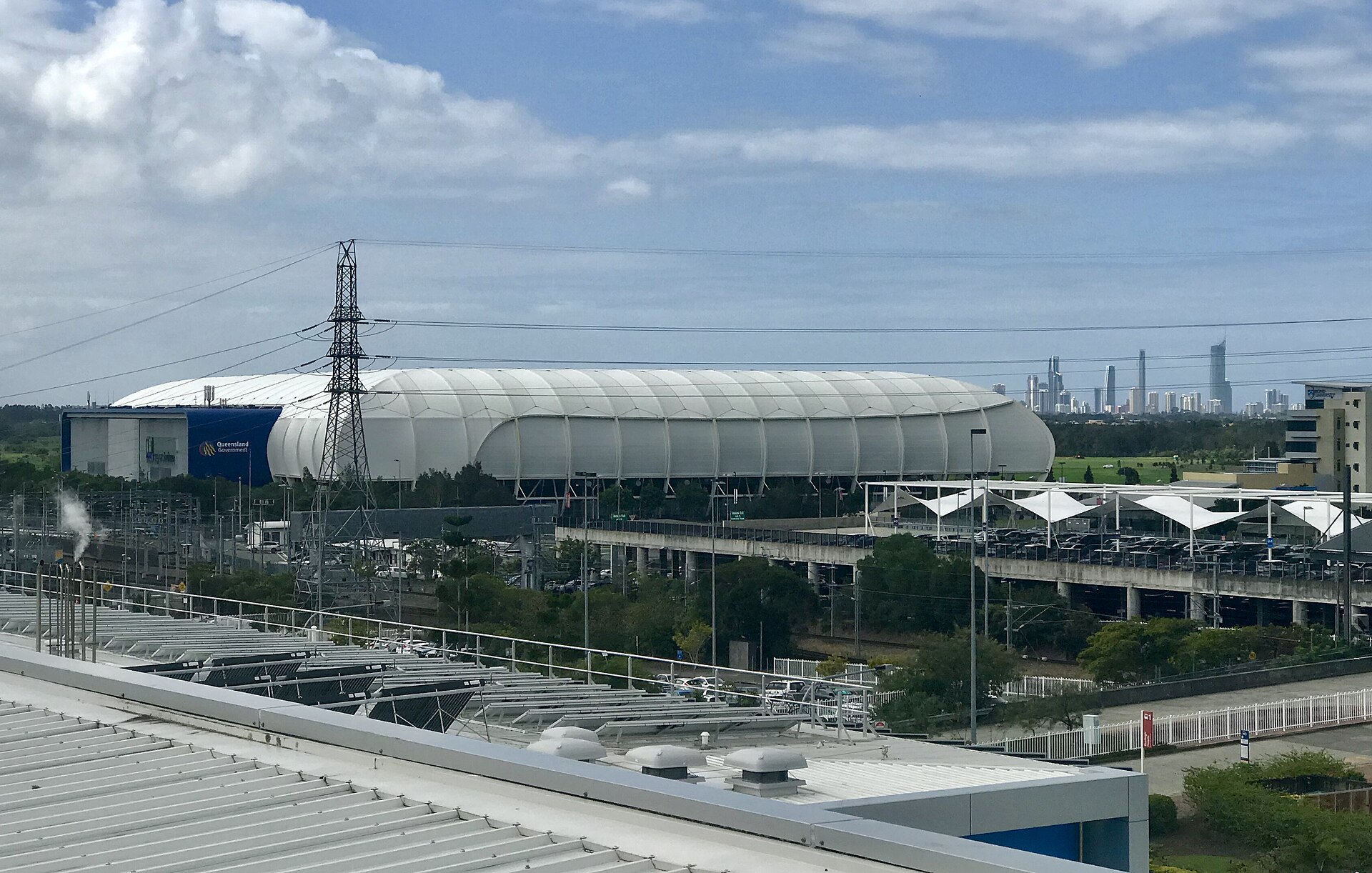 Robina Stadium seen from an elevated point beside Robina station in 2017, with the Surfers Paradise skyline behind