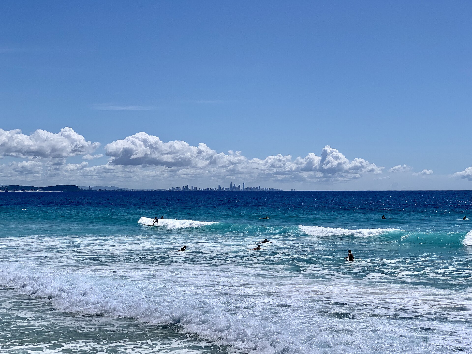 Surfers and high-rise buildings seen from the jetty between Coolangatta Beach and Kirra Beach, 2020